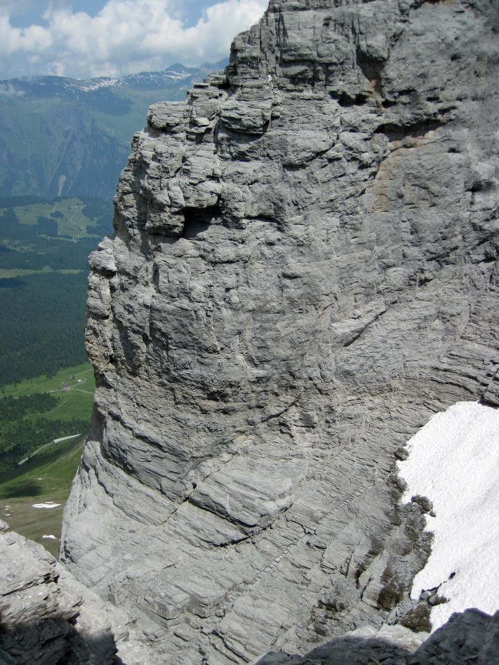 The Rotstock Via Ferrata steps are visible cutting diagonally across the Eiger and into a snow-filled scoop at the back of the gully.