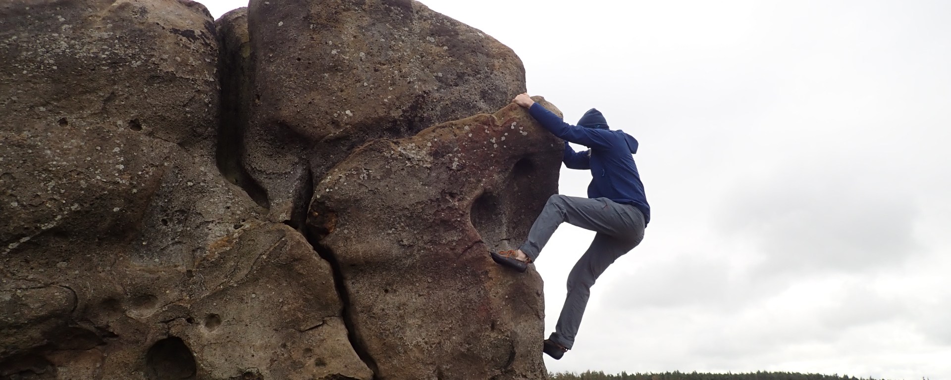 Climbing on an arete on High Man at Little Almscliff.